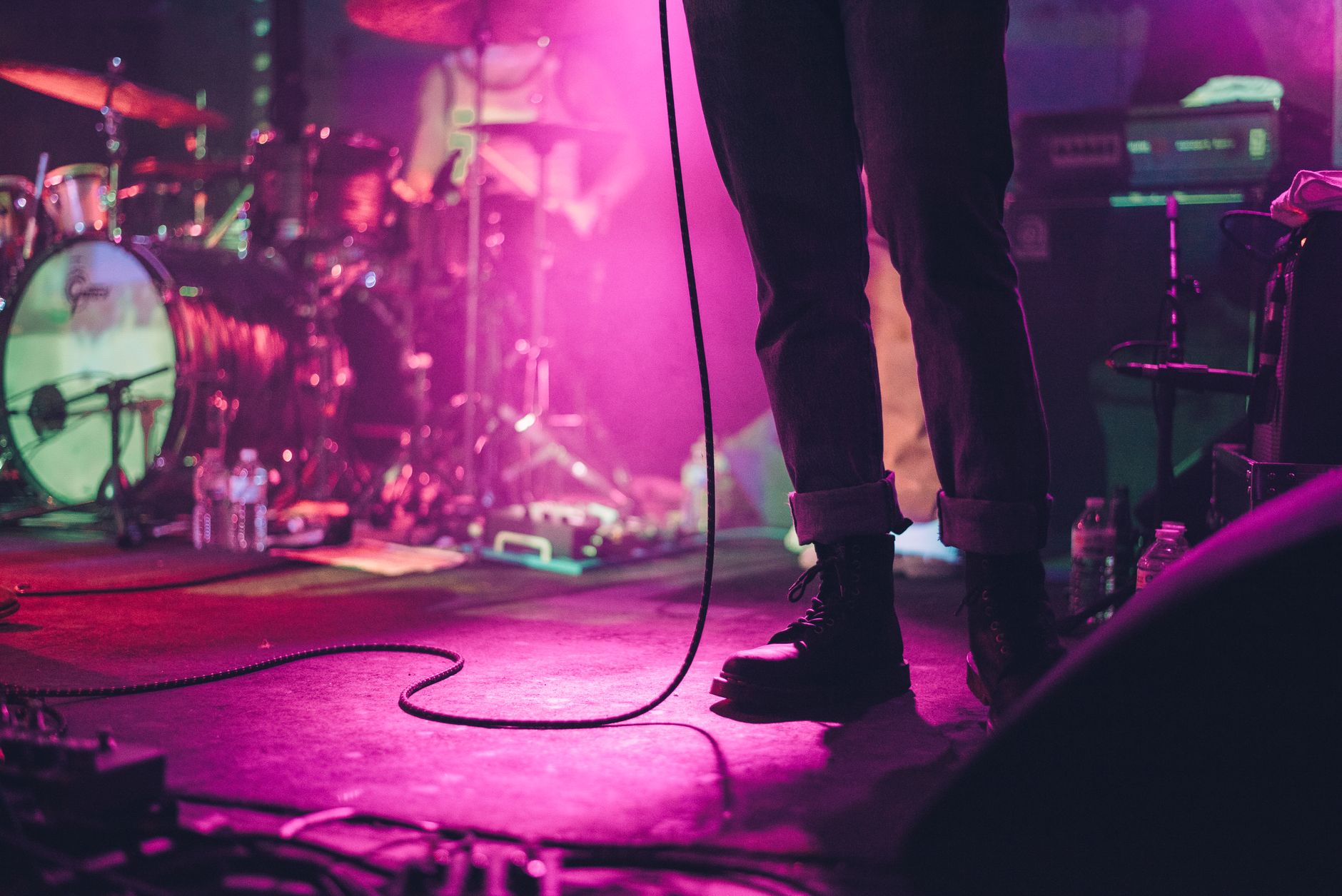 Dynamic stage performance with musical instruments under vibrant lighting.
