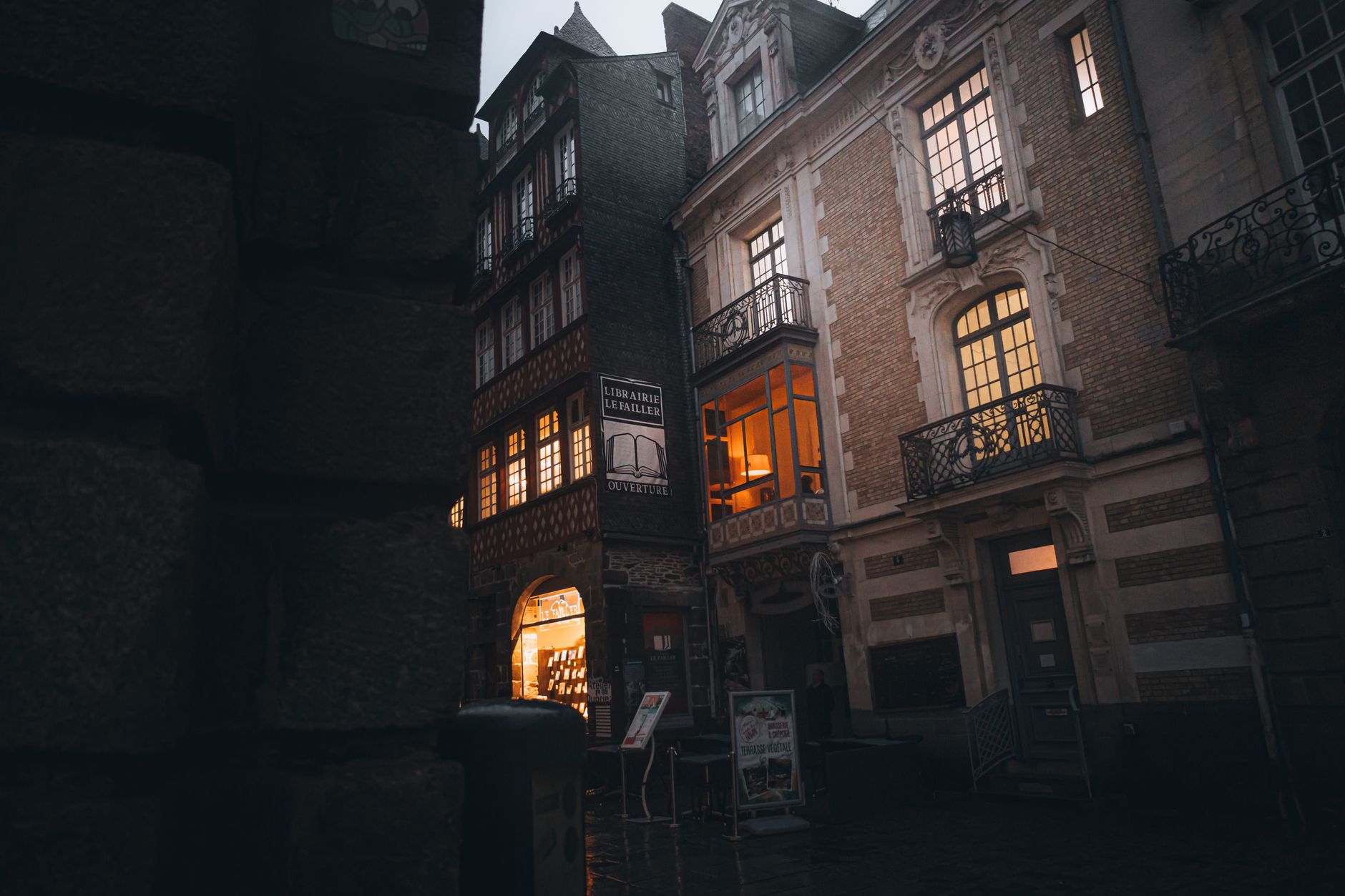 Charming view of historic French street at twilight, showcasing elegant, illuminated architecture.