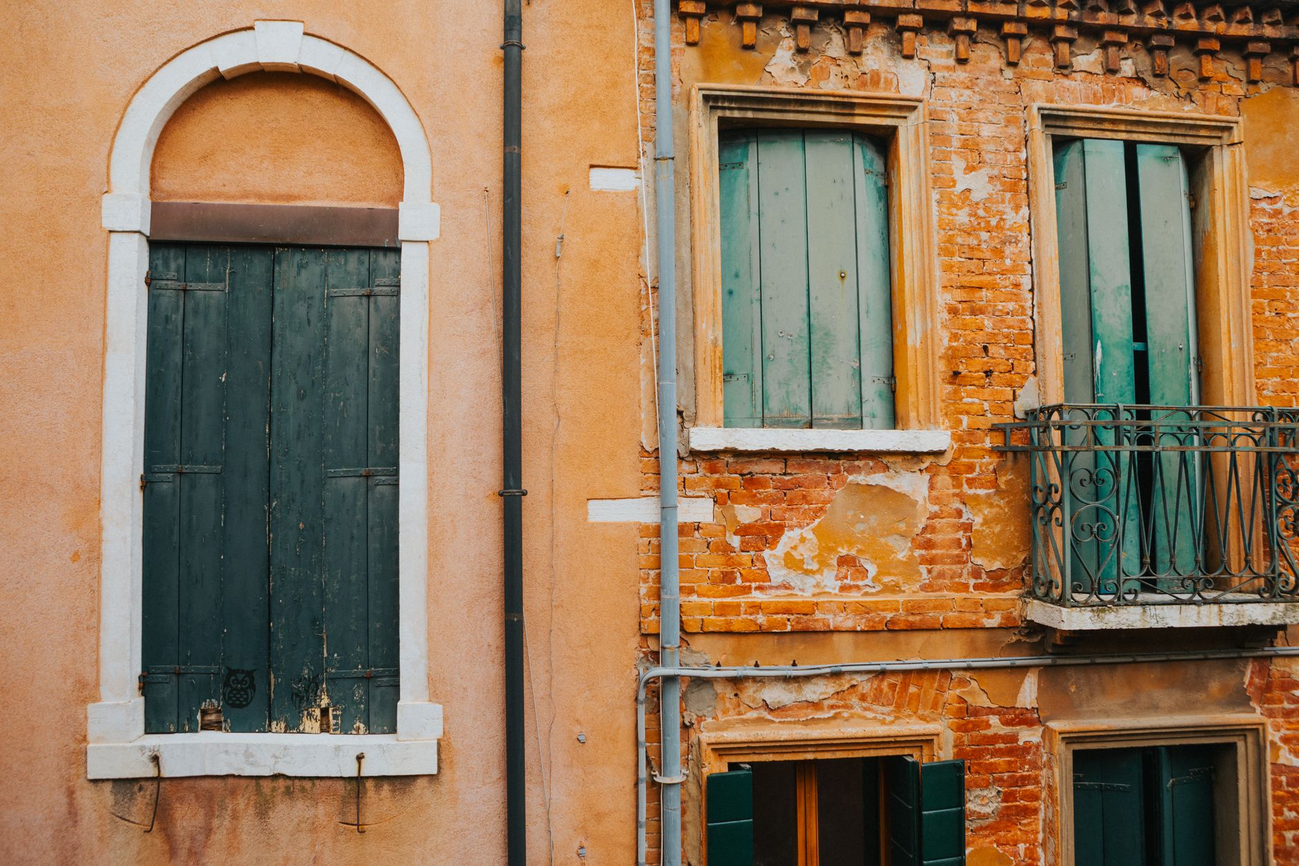 A vintage building facade with weathered shutters, showcasing rustic charm and warm tones.