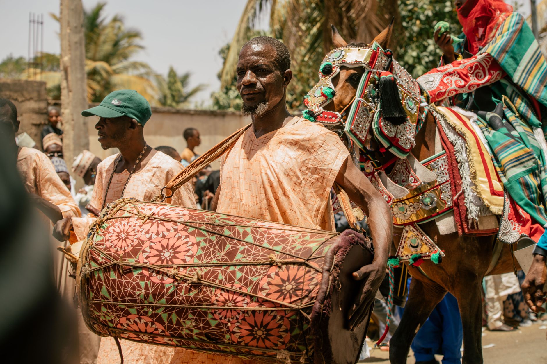 Vibrant cultural parade featuring a drummer and horse parade in traditional attire.