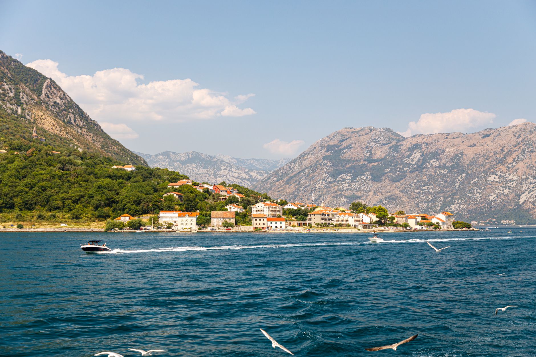 Stunning coastal town with mountains and clear sky, ideal for travel and nature photography.