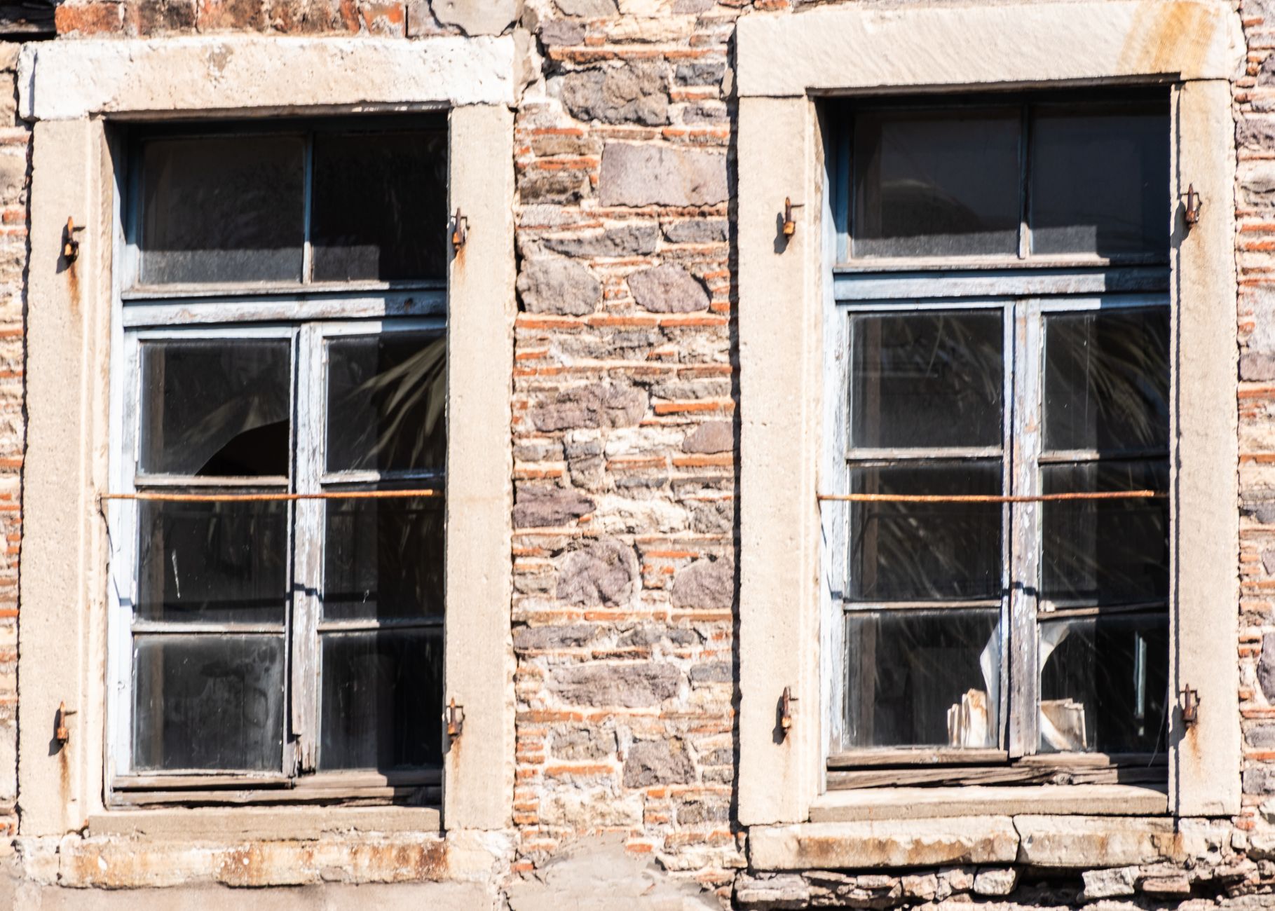 Close-up of vintage wooden windows on an old stone building facade in İzmir, Türkiye.
