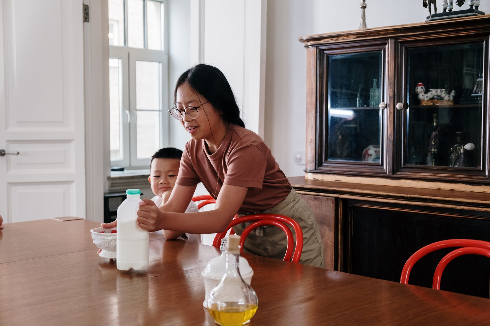 Children enjoying breakfast at home with milk on a sunny morning.