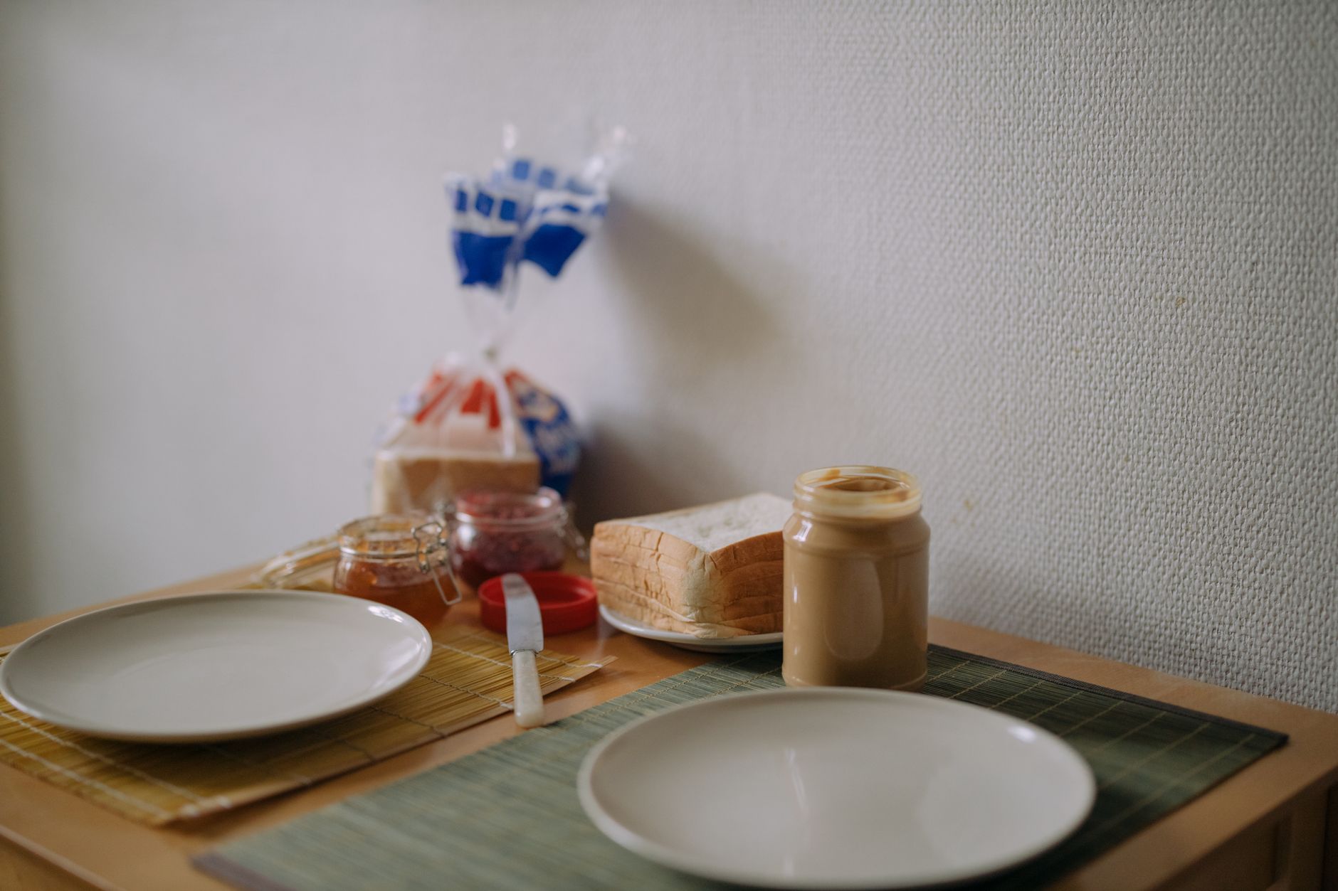 Inviting breakfast table setup with bread and peanut butter, ready for a cozy meal.